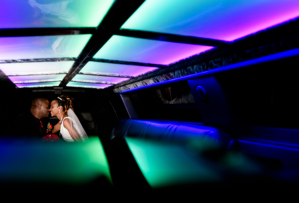 Carla + Lorenza nose to nose inside their limo with dramatic lighting, downtown pensacola, Romantic Red Rose Wedding, Lazzat Photography