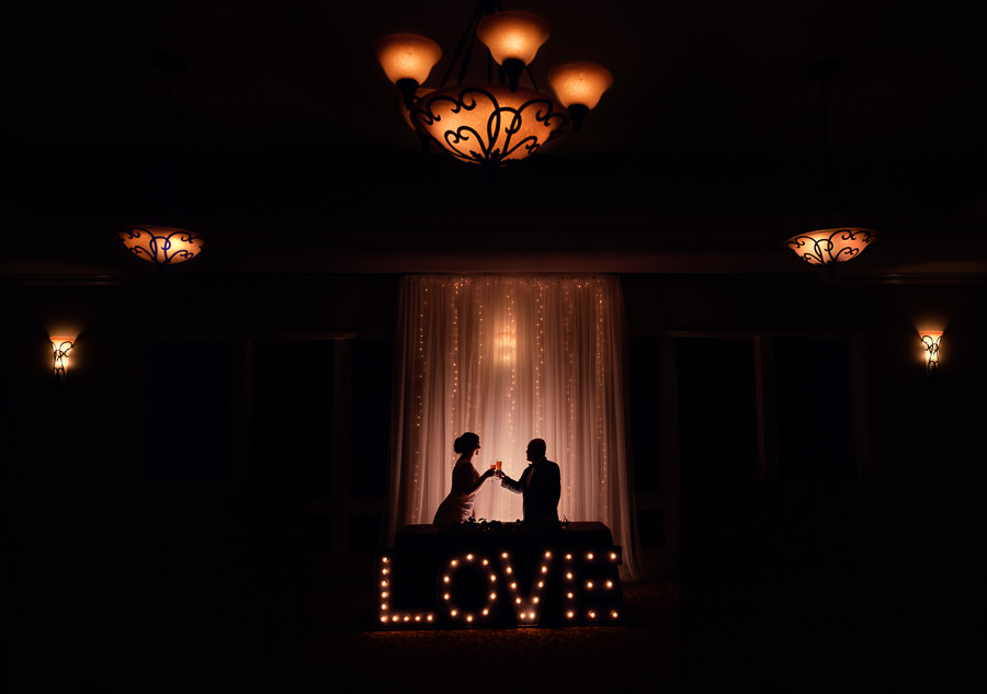 Silhouette of Bride and Groom cheers in front of LOVE light up sign, Scenic Hills Country Club, Catholic country club wedding, Pensacola Florida, Lazzat Photography